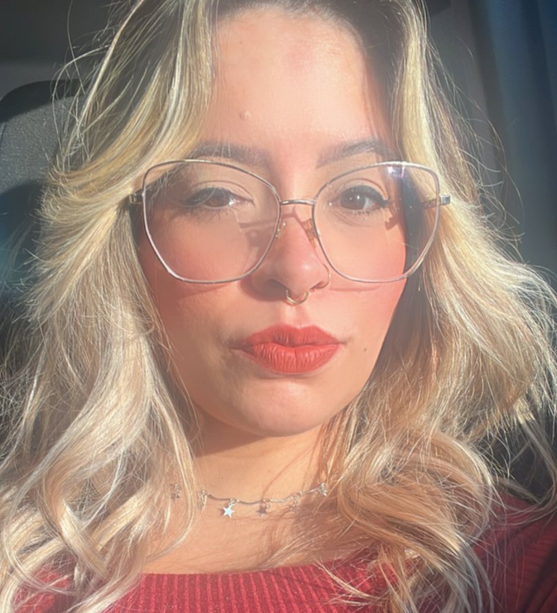 Foto de Gabriela Carvalho, de óculos e batom vermelho